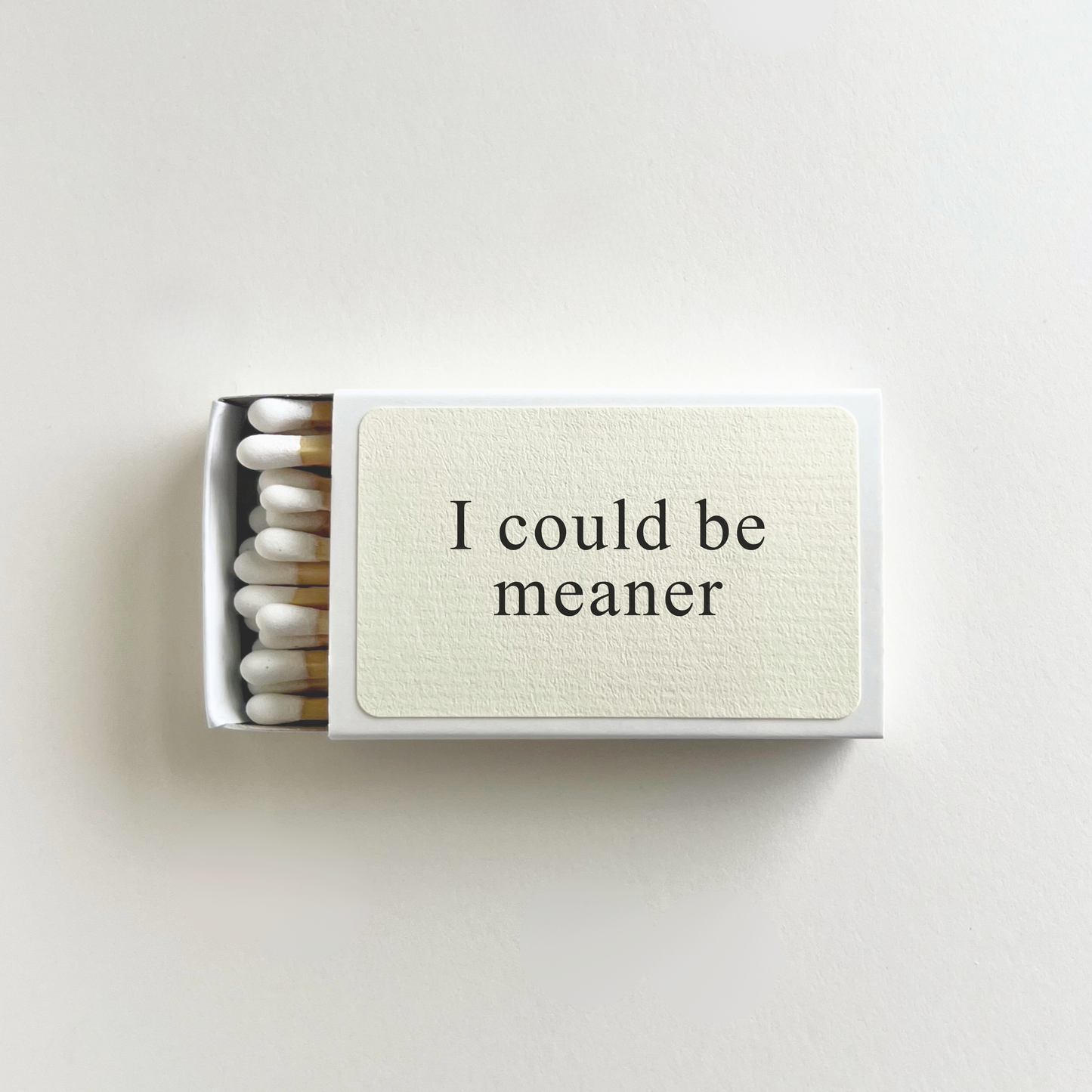 Matchbox with 'I could be meaner' text on a light background