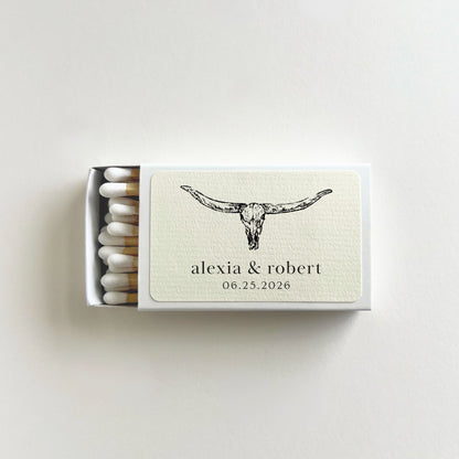 Personalized western wedding matchbook open to show white-tip matches, longhorn skull illustration, and custom couple names and wedding date on label